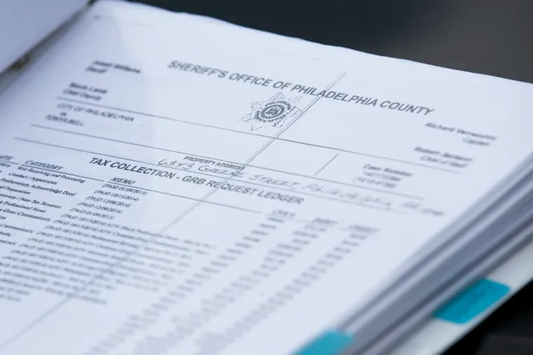 In this file photo, tax records for Tonya Bell's Germantown home from the Sheriff's Office reside in a binder full of paperwork. An ongoing shutdown of court computers have prompted legal advocates to file an emergency motion requesting the courts to postpone mortgage foreclosure and tax sales.