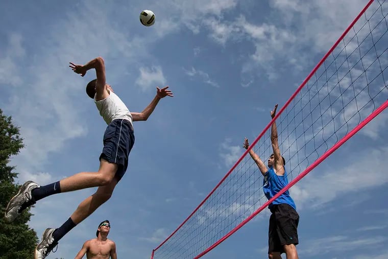 Landon Shorts, left, returns the ball on Logan Smiley during 18-and-under play at the Pottstown Rumble volleyball tournament in Manatawny Park on June 26, 2015. ( LAURENCE KESTERSON/For The Inquirer)