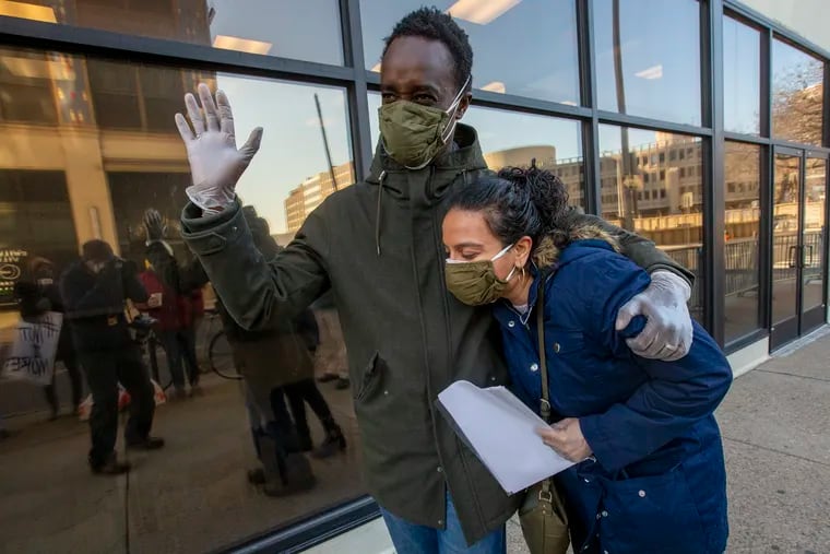 Christian M'Bagoyi, 42, embraces his wife, Sarika Kumar as they celebrate outside the Philadelphia ICE offices on N. 8th St. and Cherry St. on Friday morning February 26, 2021, after ICE did not take him into custody when he checked in with authorities. He was taken into custody last week and now faces deportation from a Louisiana facility.