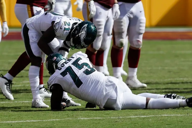 Eagles safety Jalen Mills (21) attends to injured teammate Vinny Curry (75) during the fourth quarter.