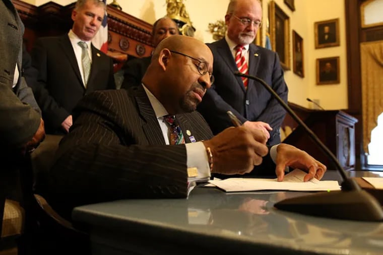 Mayor Michael Nutter signs the paid sick leave bill into law at City Hall on Feb. 12, 2015. ( DAVID MAIALETTI / Staff Photographer )