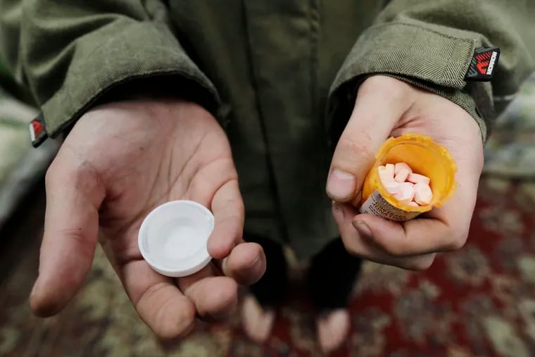 Jon Combes holds his bottle of buprenorphine, a medicine that prevents withdrawal sickness in people trying to stop using opiates, as he prepares to take a dose in a clinic in Olympia, Wash. in 2019.