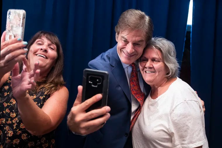 U.S. Senate candidate Dr. Mehmet Oz, center, hugs and poses for photos with Charlene Thompson, left, and Mary Lou Gula, right, following a roundtable discussion on veterans.