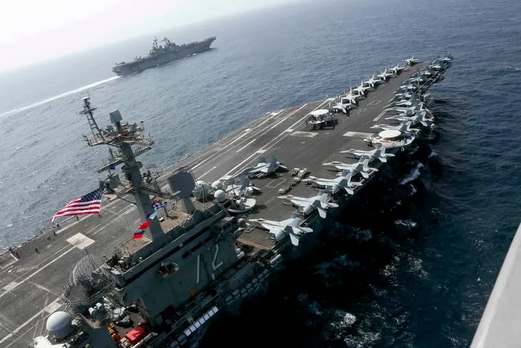 CORRECTS DATE - In this Friday, May 17, 2019, photo released by the U.S. Navy, the USS Abraham Lincoln sails in the Arabian Sea near the amphibious assault ship USS Kearsarge. Commercial airliners flying over the Persian Gulf risk being targeted by "miscalculation or misidentification" from the Iranian military amid heightened tensions between the Islamic Republic and the U.S., American diplomats warned Saturday, May 18, 2019, even as both Washington and Tehran say they don't seek war. (Mass Communication Specialist 1st Class Brian M. Wilbur, U.S. Navy via AP)