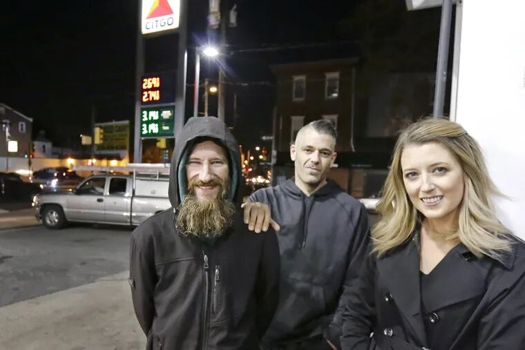 Kate McClure and her boyfriend Mark D'Amico (center) started a GoFundme page for Johnny Bobbitt Jr. (left), a homeless man who helped Kate when she was stranded. Kate ran out of gas and Johnny spent his last $20 to buy gas for her at this CITGO station. . ELIZABETH ROBERTSON / Philadelphia Inquirer