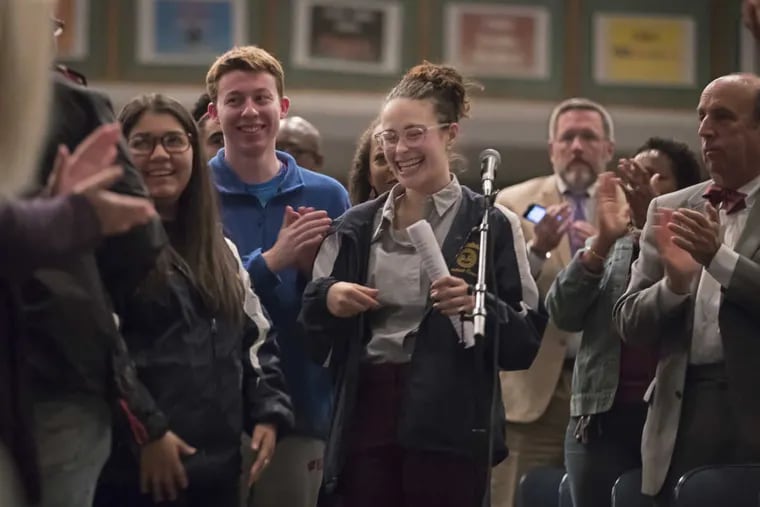 Cheltenham High School Student Council President Paige Kytzidis (center) reacts with a huge smile after receiving a standing ovation at a meeting Monday night to discuss recent school violence.