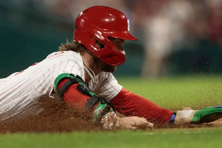 Bryce Harper slides safely into third base in the fourth inning against the New York Mets at Citizens Bank Park.
