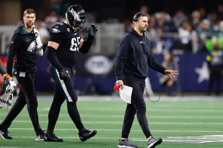 Eagles offensive tackle Lane Johnson walks off the field with coach Nick Sirianni after he was injured against the Dallas Cowboys on Saturday.