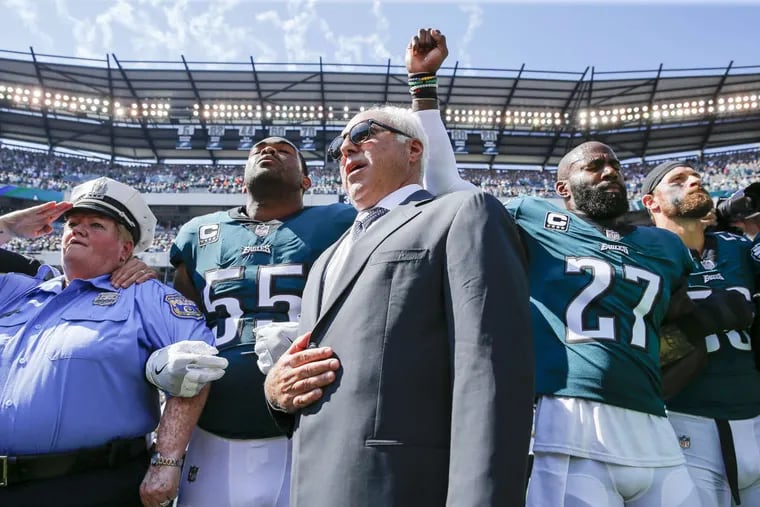 Eagles owner Jeffrey Lurie stands with Eagles defensive end Brandon Graham (55) and strong safety Malcolm Jenkins (27) during the national anthem before the Eagles play the New York Giants on Sunday, September 24, 2017.