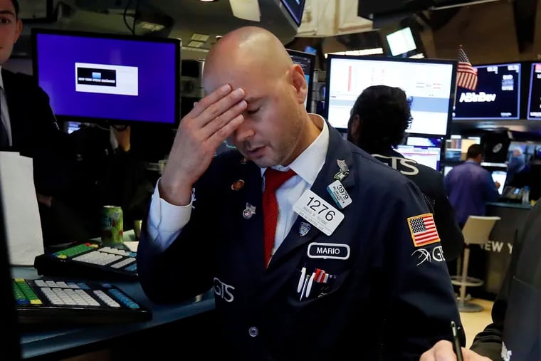 Specialist Mario Picone works on the floor of the New York Stock Exchange, Wednesday, Aug. 14, 2019. The Dow Jones Industrial Average sank 800 points after the bond market flashed a warning sign about a possible recession for the first time since 2007. (AP Photo/Richard Drew)