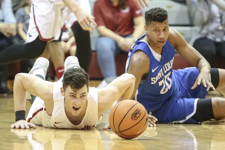 St. Joseph's Taylor Funk has an eye on the loose ball with Saint Louis' Jalen Johnson during the 2nd half at The Michael J. Hagan Arena, Wednesday, January 31, 2017. Last. Louis beats St. Joseph's 60-59. STEVEN M. FALK / Staff Photographer