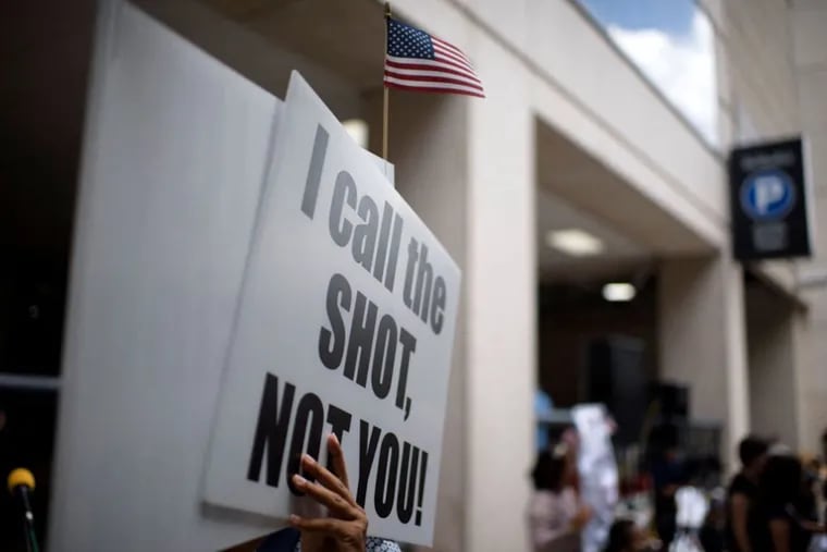 Anti-vaccine rally protesters hold signs outside of Houston Methodist Hospital in Houston, Texas, in June.