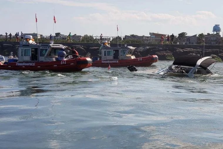 Tow boats arrive to retrieve flooded motor boat in Barnegat Inlet after the Coast Guard rescued two people from the sinking vessel.