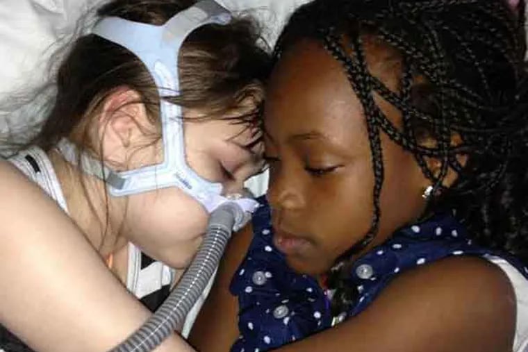 Sarah Murnaghan, 10, of Newtown Square, who has end-stage cystic fibrosis and is awaiting a lung transplant at CHOP, and her adoptive sister, Ella, 8, who was adopted from Ghana