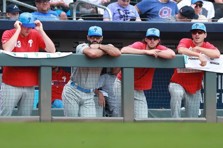 The Phillies look on from the dugout during the seventh inning of Sunday's 15-1 loss to the Braves.