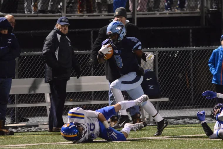 North Penn's Shamar Edwards (8) leaps over Downingtown West's Alex Rosano (6) iun Friday night's PIAA District One Class 6A semifinal contest.