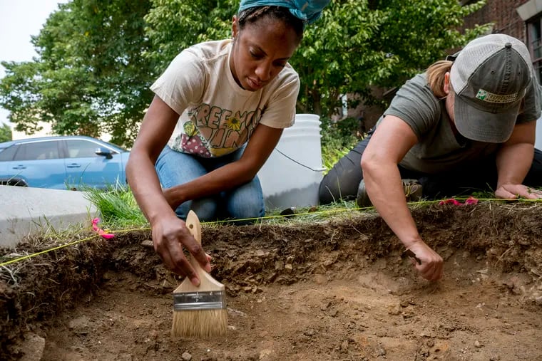 Latiaynna Tabb (left), who runs a community project management company, and Penn Museum archaeologist Megan Kassabaum work in an excavation hole at Heritage West, an urban archaeology project in the parking lot behind the Community Education Center on Lancaster Avenue.