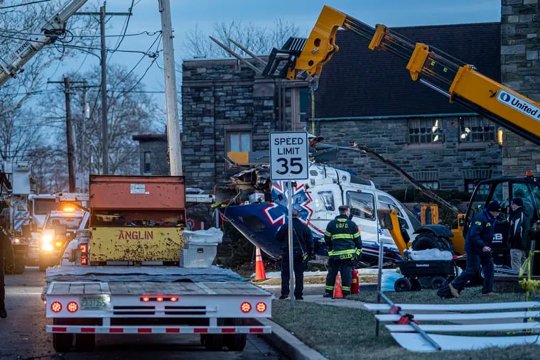 A crashed medical helicopter is removed from the scene in the Drexel Hill section of Upper Darby, Pa., on Wednesday.