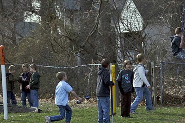 Children play in Rob Burton's yard, where the pole in the center marks the gas line. All the trees seen here are to be removed for the expansion. (John Costello / Staff Photographer)