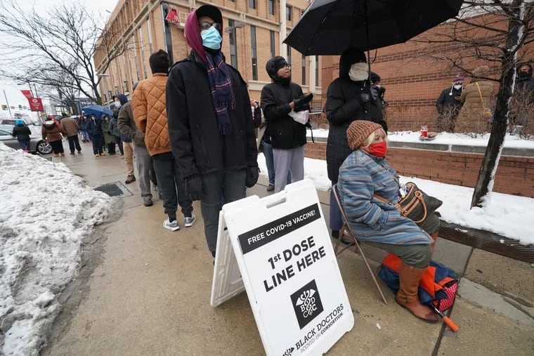 Peggy Murphy, 72, seated right, waits in line to get vaccinated for COVID-19 outside the Black Doctors COVID-19 Consortium's clinic at the Liacouras Center.