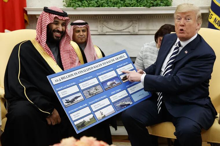 President Donald Trump holds a chart highlighting arms sales to Saudi Arabia during a meeting with Saudi Crown Prince Mohammed bin Salman in the Oval Office last March.