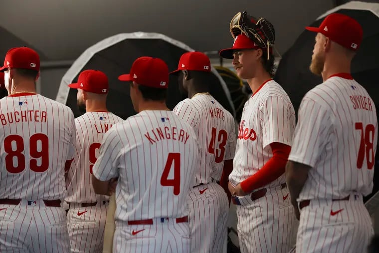Phillies players wait in their new uniforms to have their photos taken during media day in Clearwater, Fla., on Thursday.
