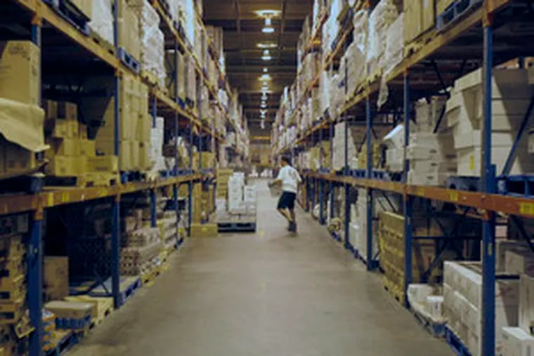 A Sysco worker removes goods from shelves in a company warehouse on Packer Avenue. The company has 500 employees in Philadelphia and 47,500 in the United States and Canada.