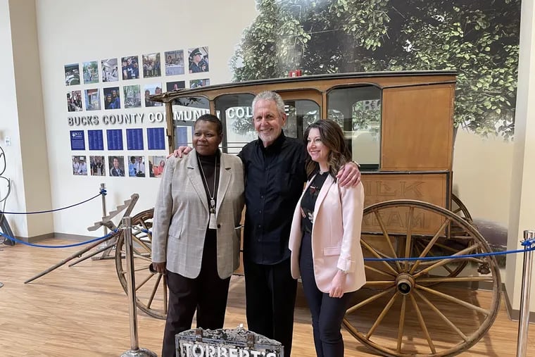 Gene Epstein (center) with college president Felicia L. Ganther (left), and Christina Kahmar (right) on Bucks County Community College's Newtown campus, after donating an original dairy wagon to display in January 2023.