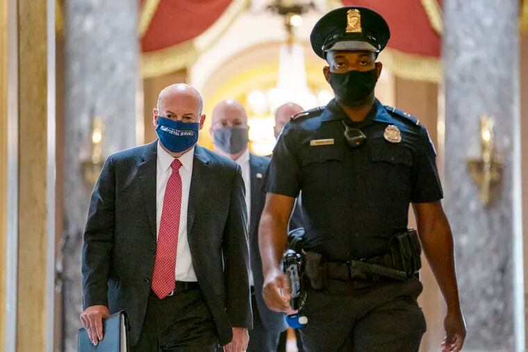 This Aug. 5 photo shows Postmaster General Louis DeJoy, left, being escorted to House Speaker Nancy Pelosi's office on Capitol Hill in Washington.