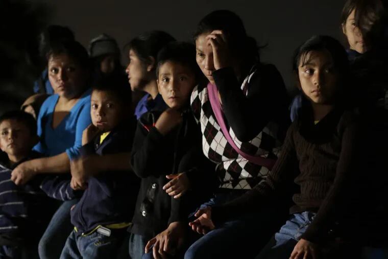 FILE - In this June 25, 2014 photo shows a group of  immigrants from Honduras and El Salvador who crossed the U.S.-Mexico border illegally are stopped in Granjeno, Texas. The influx at the border is largely families with children or by minors traveling alone. (AP Photo/Eric Gay, File)