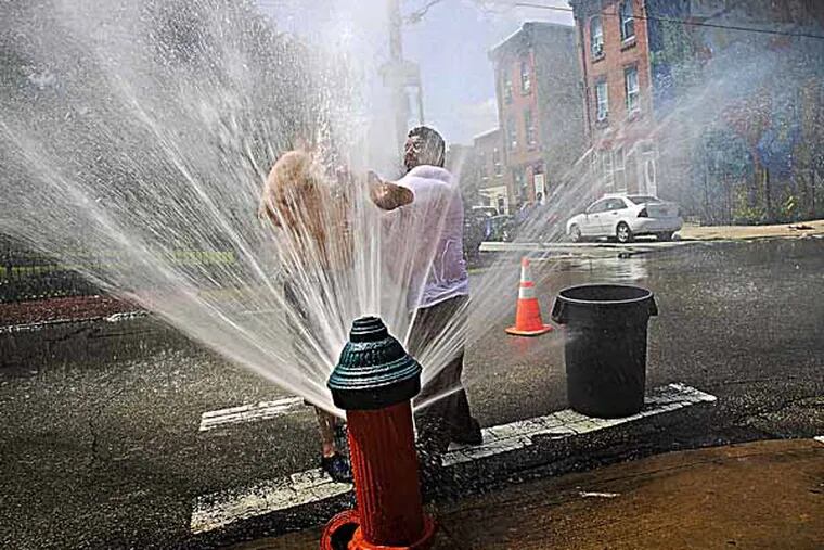 In the hydrant are Jose Candelaria and Hector Colon (right) as they cool off from the high temperatures on Tuesday afternoon. ( ALEJANDRO A. ALVAREZ / STAFF PHOTOGRAPHER )
