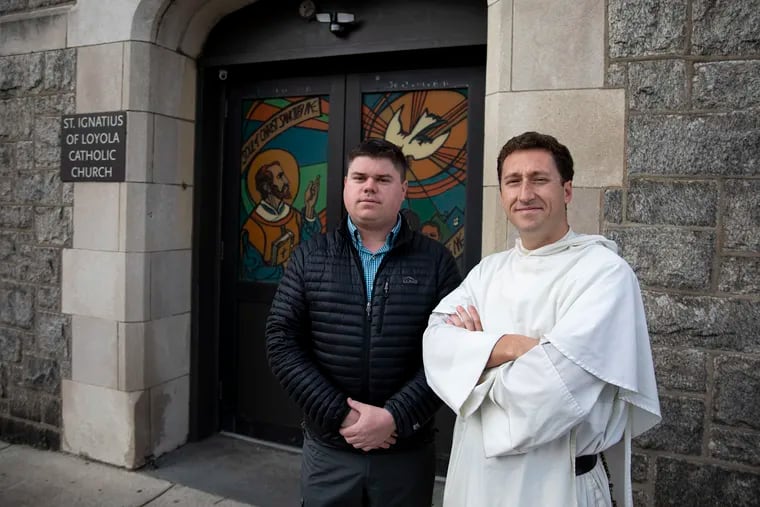 Dane Connelly, 31, of Ardmore, and Father Timothy Danaher, 32, of Center City, pose in front of St. Ignatius Church, where Kobe Bryant’s grandparents went to Mass and got married. Father Danaher and Connelly are college friends from the University of Steubenville searching to find where Bryant was baptized.