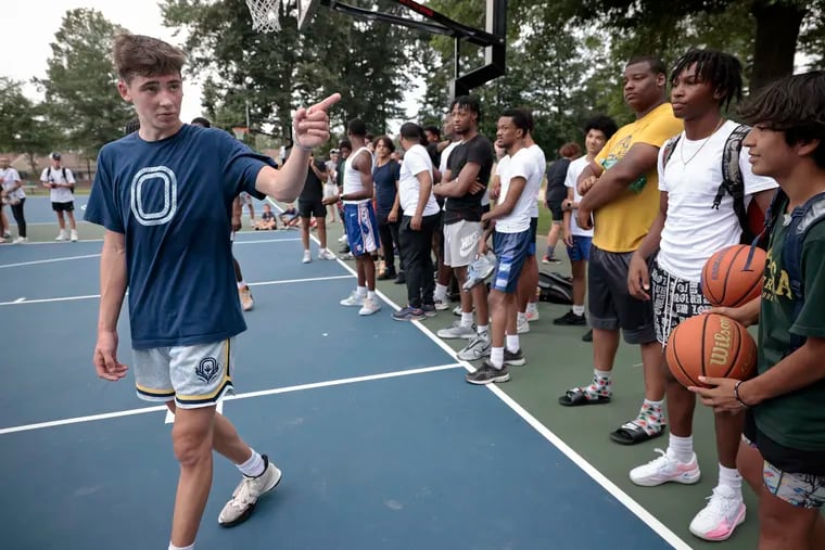 George School boys' basketball player Jake West (left) asks people if they want to come into the game during his "park takeover" basketball event at Wentz Run Park in Blue Bell, Pa. on Saturday, August 5, 2023. West is an influencer on TikTok with more than 1 million followers. He's receiving numerous Division I scholarship offers.
