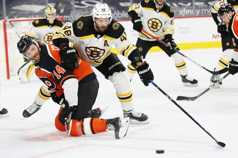 Sean Couturier and Boston's David Krejci fight for the puck during the first period of Saturday's game at the Wells Fargo Center.