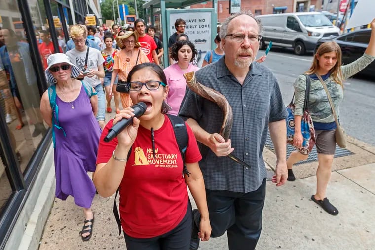 Blanca Pacheco, center, leads the chants of protesters as they circle the block where ICE has their headquarters, on Eighth Street in Philadelphia on Monday. To her left is Rabbi Shawn Zevits of Mishkan Shalom.