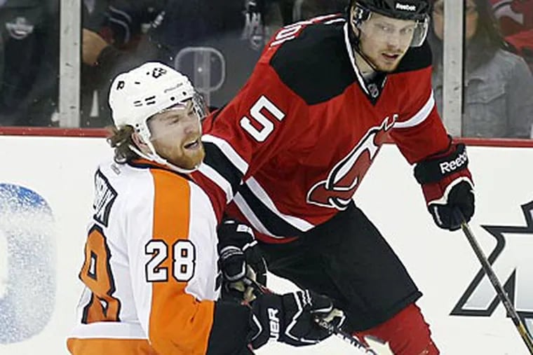 Claude Giroux gets taken against the Devils' Adam Larsson during the first period of Game 3. (Yong Kim/Staff Photographer)