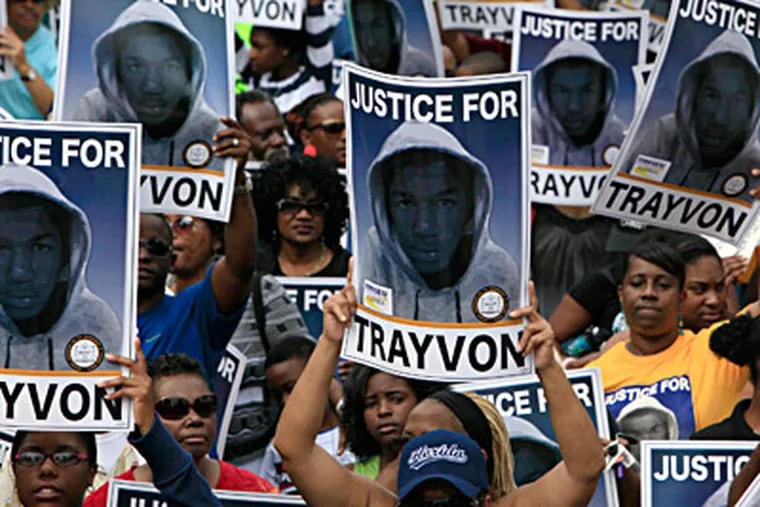 Protesters in Sanford, Fla., where Trayvon Martin was shot to death Feb. 26, hold signs urging justice for the teenager, whose killer, George Zimmerman, has claimed self-defense and has not been arrested. JULIE FLETCHER / Associated Press