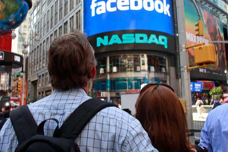 Visitors to Manhattan watch the monitor welcoming Facebook before the start of trading. "It wasn't quite as exciting as it could have been," one analyst said. (Bebeto Matthews / AP)