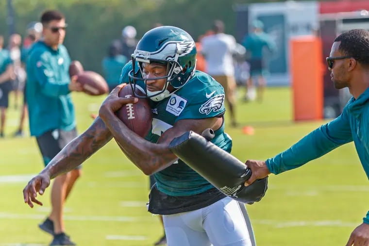 Eagle wide receiver Alshon Jeffery protects the ball from a hard slap from an assistant coach during passing drills at  Eagles training camp at the NovaCare Center on Monday July 29, 2019.