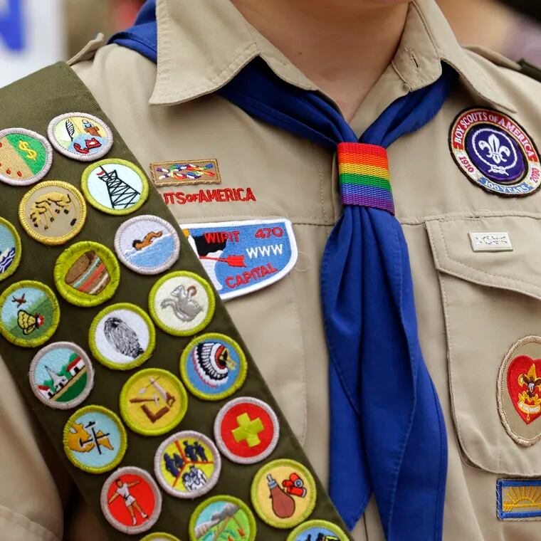 Merit badges and a rainbow-colored neckerchief slider are affixed on a Boy Scout uniform outside the headquarters of Amazon in Seattle.