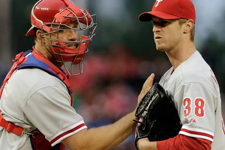 Erik Kratz (left) pats starting pitcher Kyle Kendrick (38) on the chest as he departs the mound after talking during the second inning of a baseball game against the Washington Nationals at Nationals Park,Friday, May 24, 2013, in Washington. (Alex Brandon/AP)