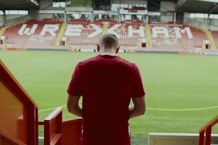 Paul Mullin walks into the Racecourse Ground in Wrexham, the oldest football stadium in the world still in continuous use.