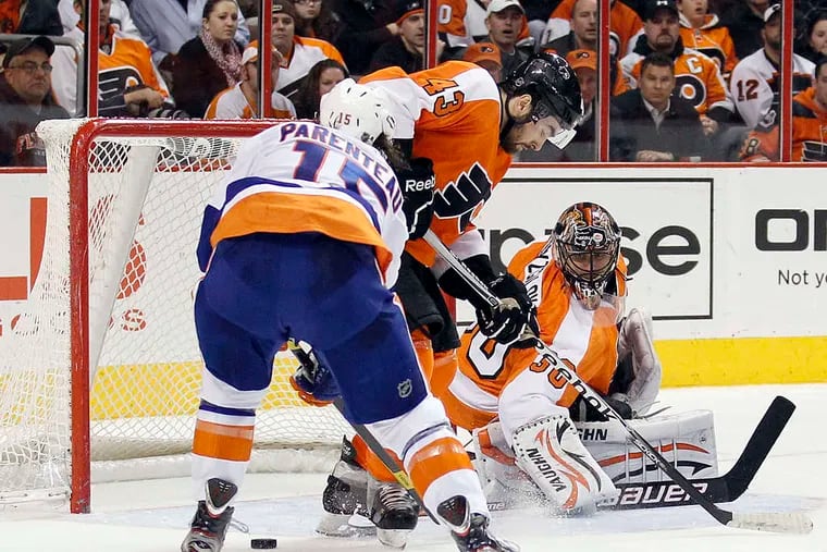 Ilya Bryzgalov and Marc-Andre Bourdon hold off Islander P.A. Parenteau in front of Flyers' net.