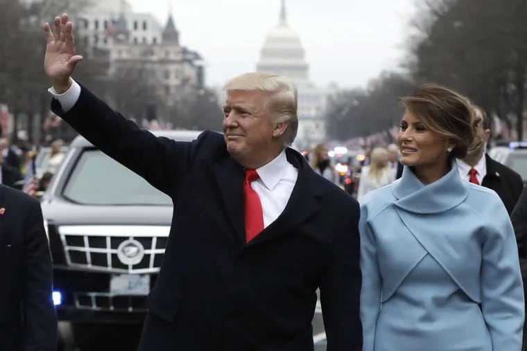 President Trump waves as he walks with first lady Melania Trump during the inauguration parade on Pennsylvania Avenue in Washington on Jan. 20, 2017.