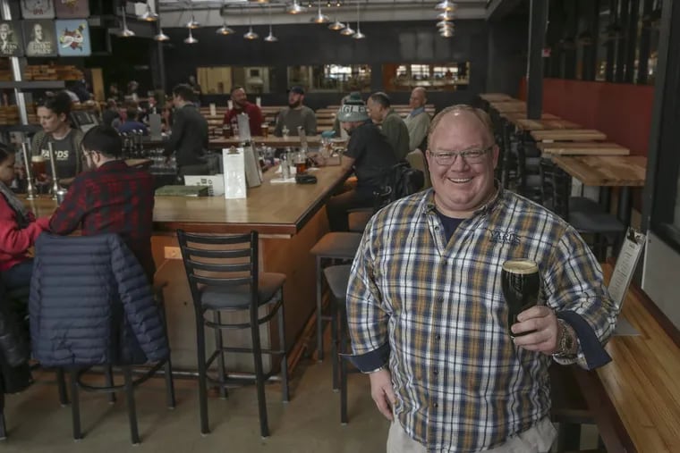 Tom Kehoe, co-owner and founder of the Yards Brewing Co., lifts a pint in the taproom of the brewery’s massive new Spring Garden location.