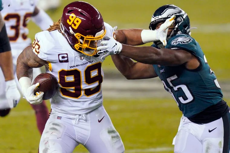 Washington Football Team's Chase Young (99) tries to get past the Eagles' Boston Scott (35) after recovering a loose snap during the second half of last year's season finale in Philadelphia.