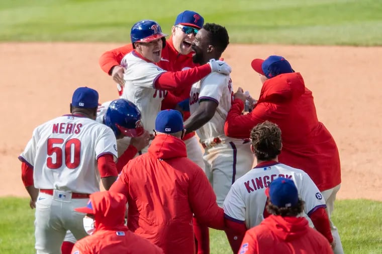 Andrew Knapp  is congratulated by Phillies teammates after his RBI single won the game in the ninth inning.