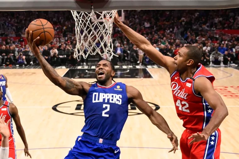 Los Angeles Clippers forward Kawhi Leonard, left, shoots as Sixers center Al Horford defends in Sunday's game at the Staples Center.