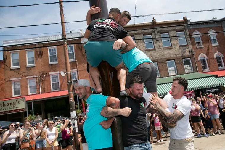 The Grease Pole contest went on despite the stifling heat last year at the South 9th Street Italian Market Festival.