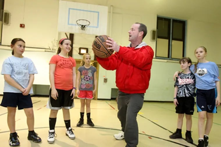 Fox Rok Athletic Association basketball commissioner Joe Grant instructs 10-year-old girls before a drill at the Fox Chase School. He now must tell parents the program is suspended. (Charles Fox / Staff Photographer)